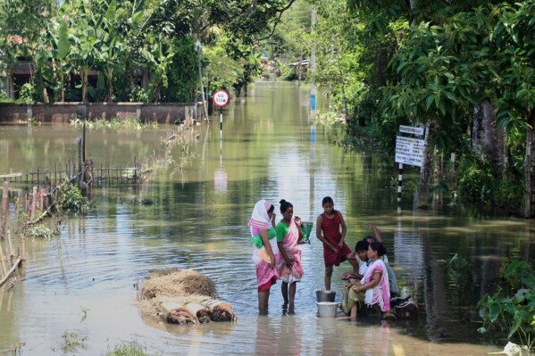 Residents collecting essentials in floodwater in Assam